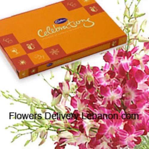 Un bellissimo mazzo di orchidee rosa insieme a una bellissima scatola di cioccolatini Cadbury
