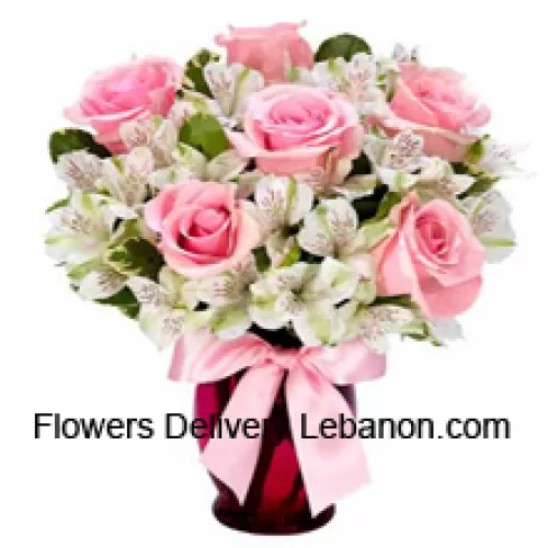 Rose rosa e alstroemeria bianca disposte splendidamente in un vaso di vetro
