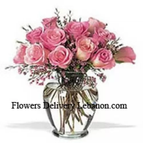 Strauß aus 12 rosa Rosen mit einigen Farnen in einer Vase